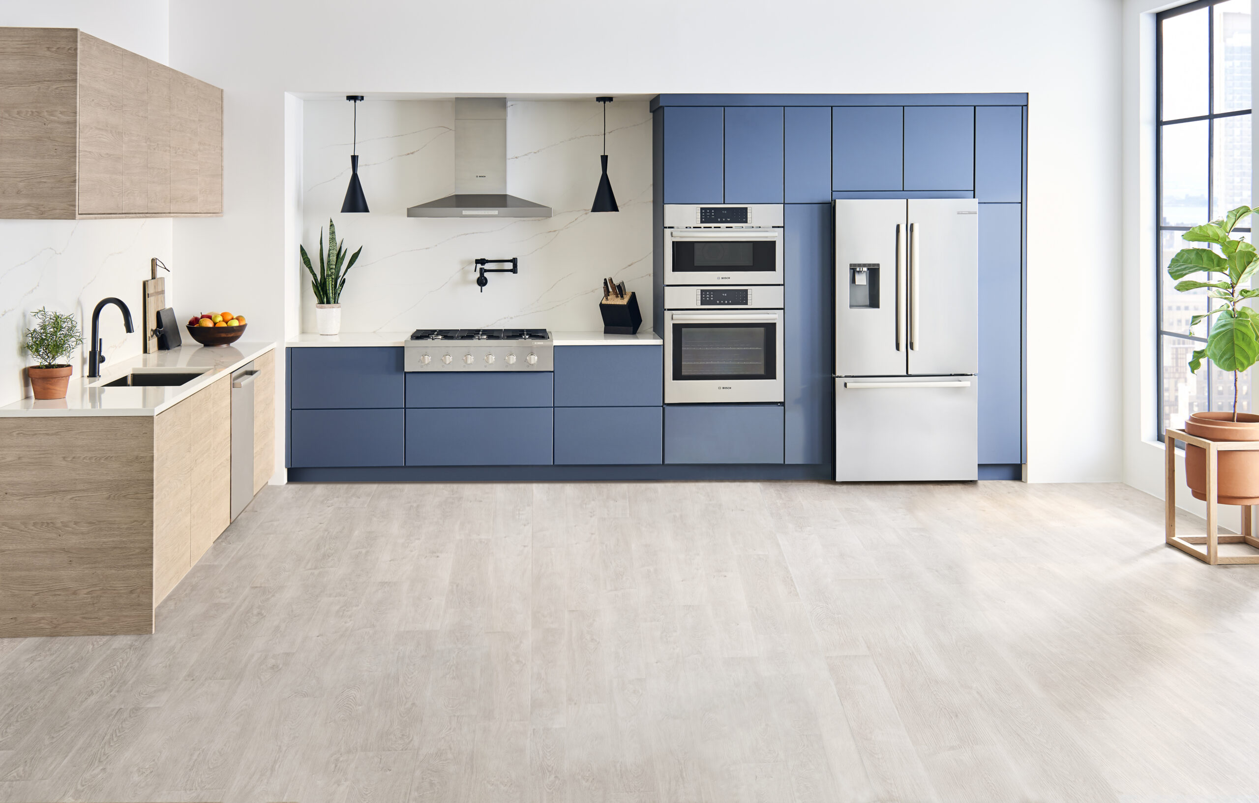 Kitchen featuring a mix of blue and wood-tone cabinets and stainless steel appliances